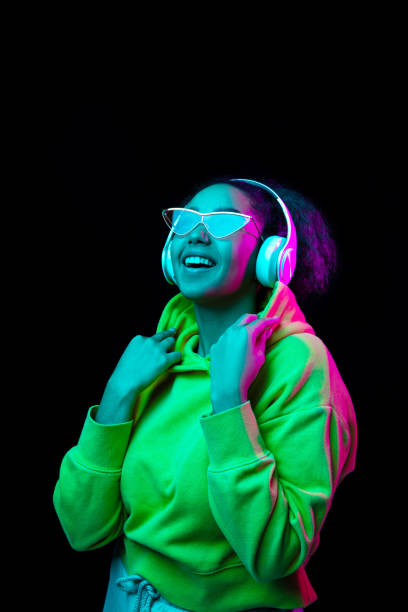 istock African-american woman's portrait isolated on dark studio background in multicolored neon light 1297171645