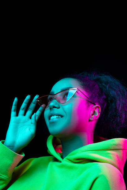 istock African-american woman's portrait isolated on dark studio background in multicolored neon light 1297171648