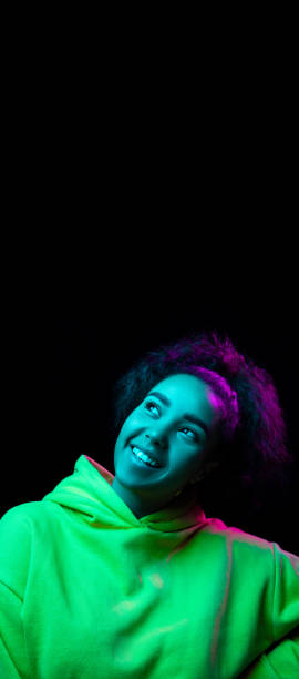 istock African-american woman's portrait isolated on dark studio background in multicolored neon light 1297171649