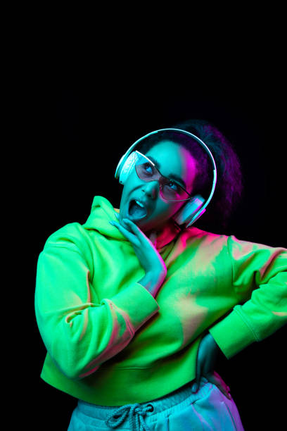 istock African-american woman's portrait isolated on dark studio background in multicolored neon light 1297171653