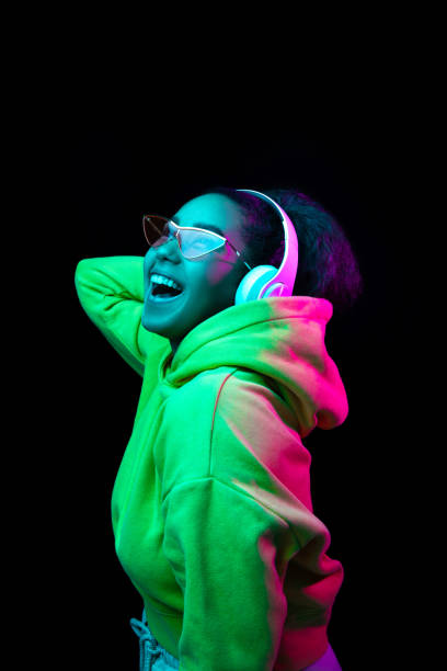 istock African-american woman's portrait isolated on dark studio background in multicolored neon light 1297171655