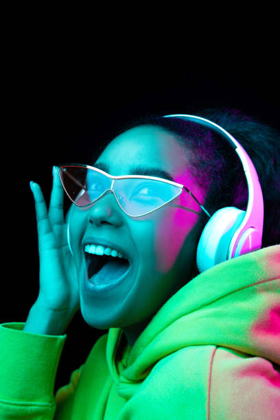 istock African-american woman's portrait isolated on dark studio background in multicolored neon light 1297171657