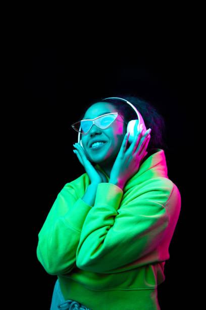 istock African-american woman's portrait isolated on dark studio background in multicolored neon light 1297171658