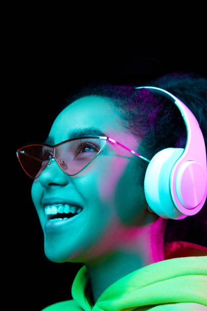 istock African-american woman's portrait isolated on dark studio background in multicolored neon light 1297171661