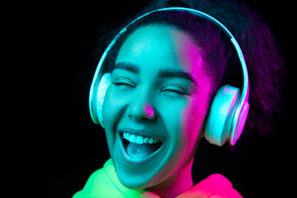 istock African-american woman's portrait isolated on dark studio background in multicolored neon light 1297171662