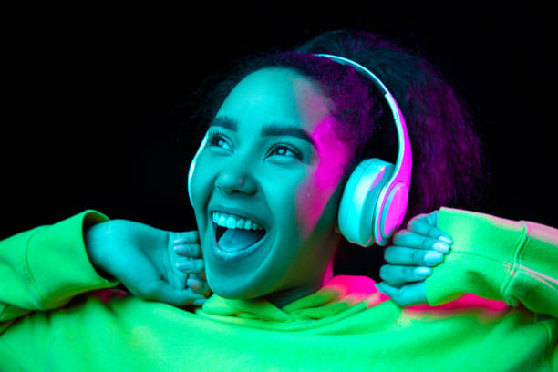 istock African-american woman's portrait isolated on dark studio background in multicolored neon light 1297171664