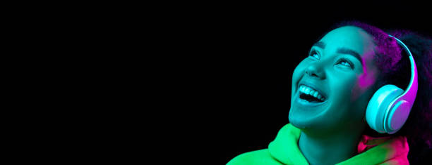 istock African-american woman's portrait isolated on dark studio background in multicolored neon light 1297171667