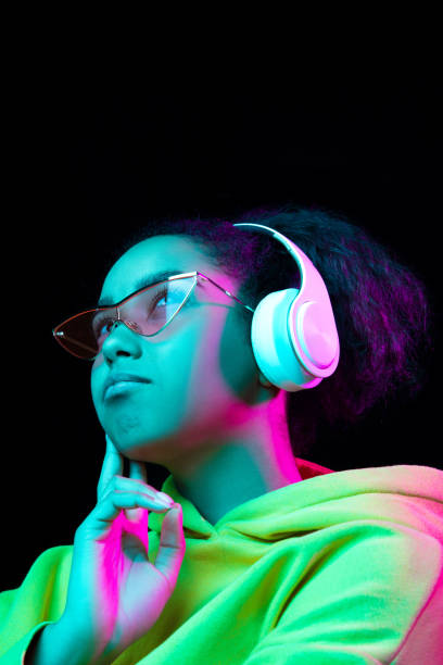 istock African-american woman's portrait isolated on dark studio background in multicolored neon light 1297171668