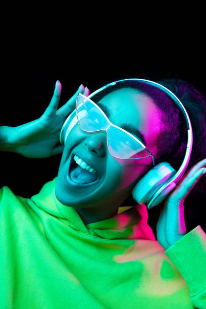 istock African-american woman's portrait isolated on dark studio background in multicolored neon light 1297171672