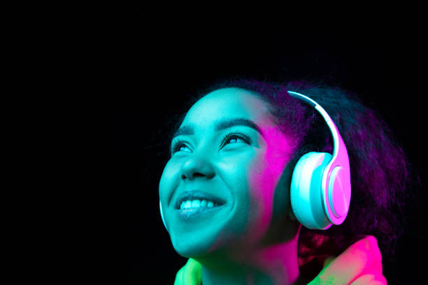 istock African-american woman's portrait isolated on dark studio background in multicolored neon light 1297171674