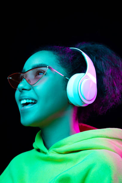 istock African-american woman's portrait isolated on dark studio background in multicolored neon light 1297171675