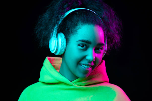istock African-american woman's portrait isolated on dark studio background in multicolored neon light 1297171677