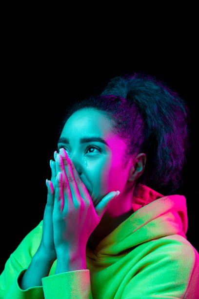 istock African-american woman's portrait isolated on dark studio background in multicolored neon light 1297171680