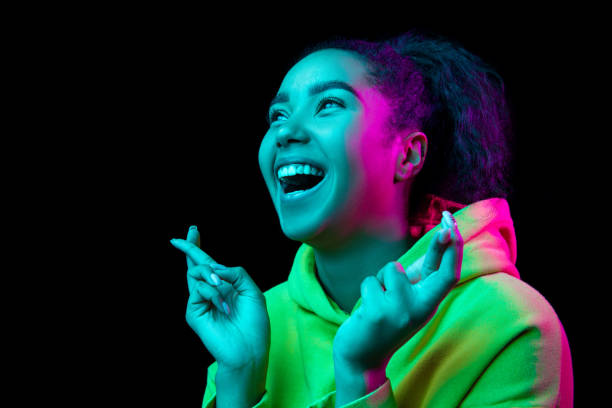 istock African-american woman's portrait isolated on dark studio background in multicolored neon light 1297171681