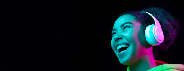 istock African-american woman's portrait isolated on dark studio background in multicolored neon light 1297171683