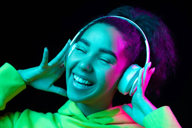 istock African-american woman's portrait isolated on dark studio background in multicolored neon light 1297171686