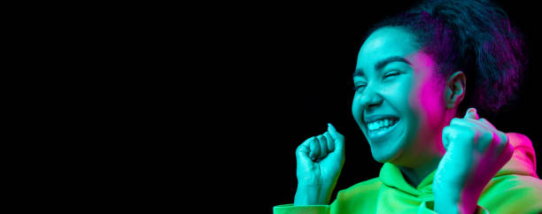 istock African-american woman's portrait isolated on dark studio background in multicolored neon light 1297171689