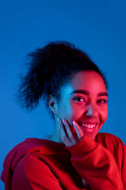istock African-american woman's portrait isolated on blue studio background in multicolored neon light 1297171882