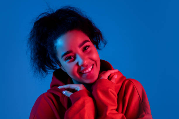 istock African-american woman's portrait isolated on blue studio background in multicolored neon light 1297171883