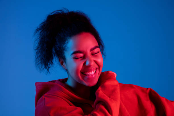 istock African-american woman's portrait isolated on blue studio background in multicolored neon light 1297171885
