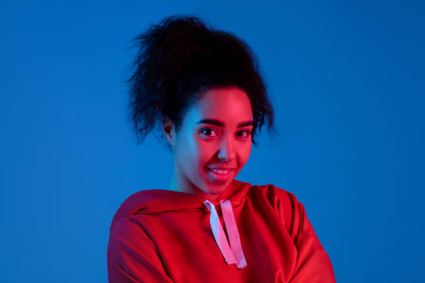 istock African-american woman's portrait isolated on blue studio background in multicolored neon light 1297171892