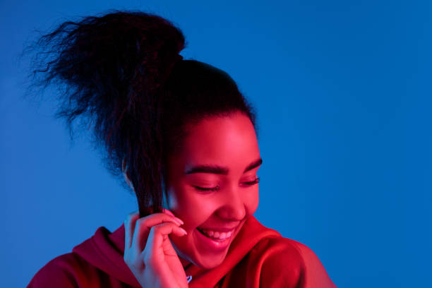 istock African-american woman's portrait isolated on blue studio background in multicolored neon light 1297171896