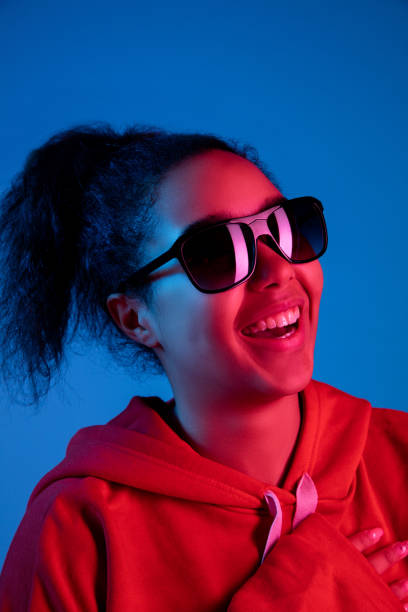 istock African-american woman's portrait isolated on blue studio background in multicolored neon light 1297171898