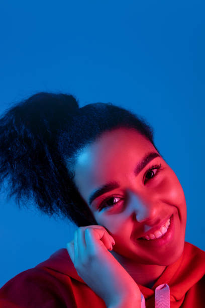 istock African-american woman's portrait isolated on blue studio background in multicolored neon light 1297171900