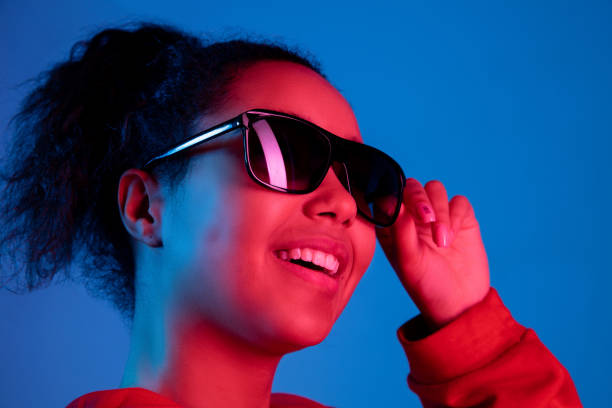 istock African-american woman's portrait isolated on blue studio background in multicolored neon light 1297171903