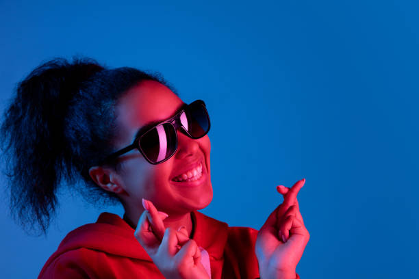 African-american woman's portrait isolated on blue studio background in multicolored neon light