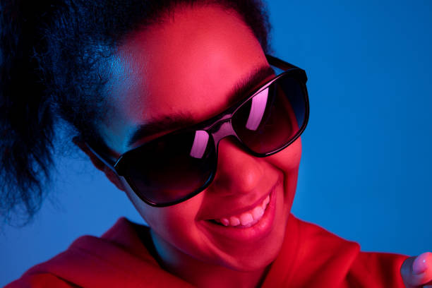 istock African-american woman's portrait isolated on blue studio background in multicolored neon light 1297171908