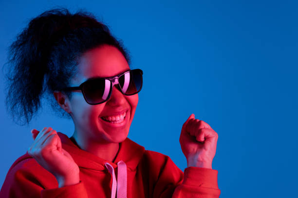 istock African-american woman's portrait isolated on blue studio background in multicolored neon light 1297171909