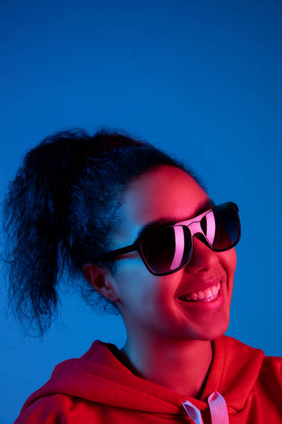 istock African-american woman's portrait isolated on blue studio background in multicolored neon light 1297171910