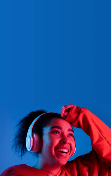 istock African-american woman's portrait isolated on blue studio background in multicolored neon light 1297171919