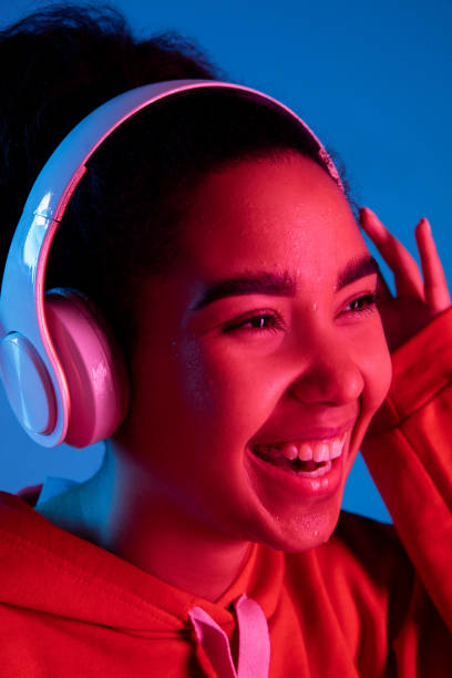 istock African-american woman's portrait isolated on blue studio background in multicolored neon light 1297171927
