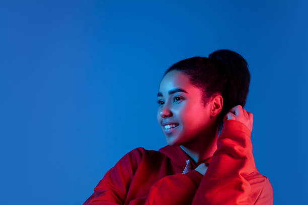 istock African-american woman's portrait isolated on blue studio background in multicolored neon light 1297171944