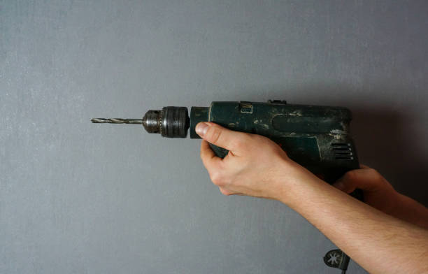 istock a man's hand holds an electric drill 1297173002