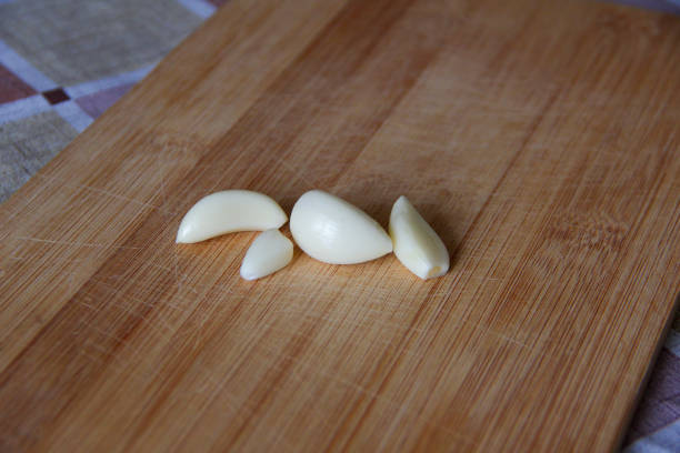 istock Garlic cloves on wooden board 1297173487