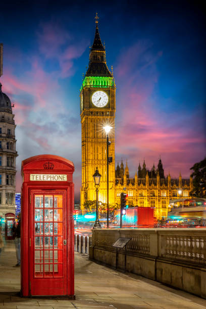 ロンドンの照明付きビッグベン時計塔の前にある赤い電話ブース - red telephone box ストックフォトと画像