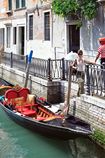 Venice. Italy - May 1, 2007: An attractive woman gets out of the gondola after touring Venice
