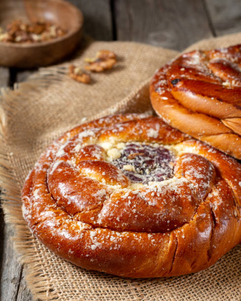 Buns with jam on a wooden table. Pie with cherry jam and marzipan. Rustic delicious pastries