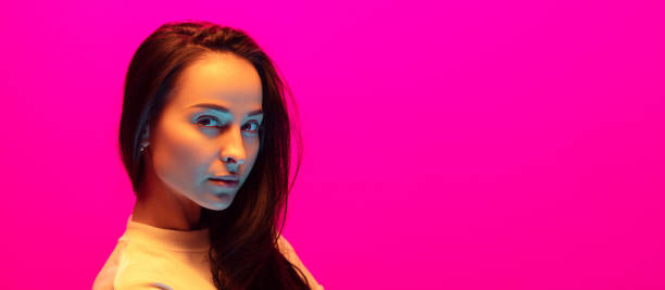 istock Caucasian beautiful woman's portrait isolated on pink studio background in multicolored neon light 1297174839