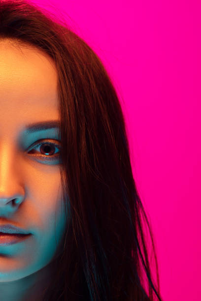 istock Caucasian beautiful woman's portrait isolated on pink studio background in multicolored neon light 1297174844