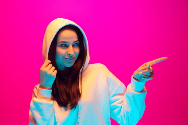 istock Caucasian beautiful woman's portrait isolated on pink studio background in multicolored neon light 1297174862