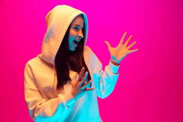 istock Caucasian beautiful woman's portrait isolated on pink studio background in multicolored neon light 1297174865