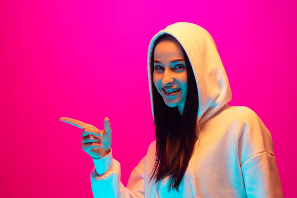 istock Caucasian beautiful woman's portrait isolated on pink studio background in multicolored neon light 1297174870
