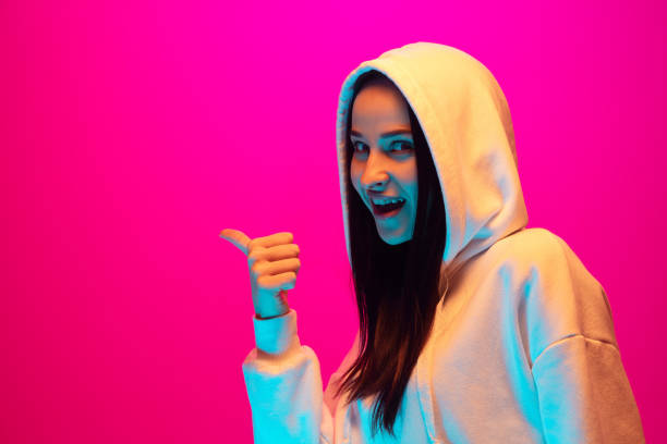 istock Caucasian beautiful woman's portrait isolated on pink studio background in multicolored neon light 1297174871