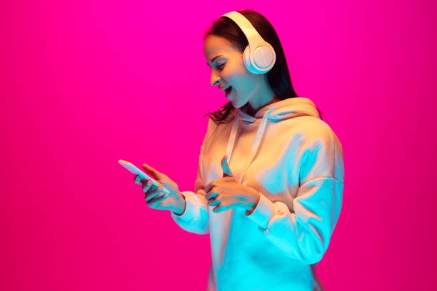istock Caucasian beautiful woman's portrait isolated on pink studio background in multicolored neon light 1297174875