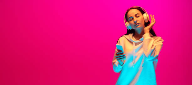 istock Caucasian beautiful woman's portrait isolated on pink studio background in multicolored neon light 1297174877