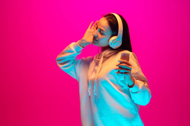 istock Caucasian beautiful woman's portrait isolated on pink studio background in multicolored neon light 1297174878